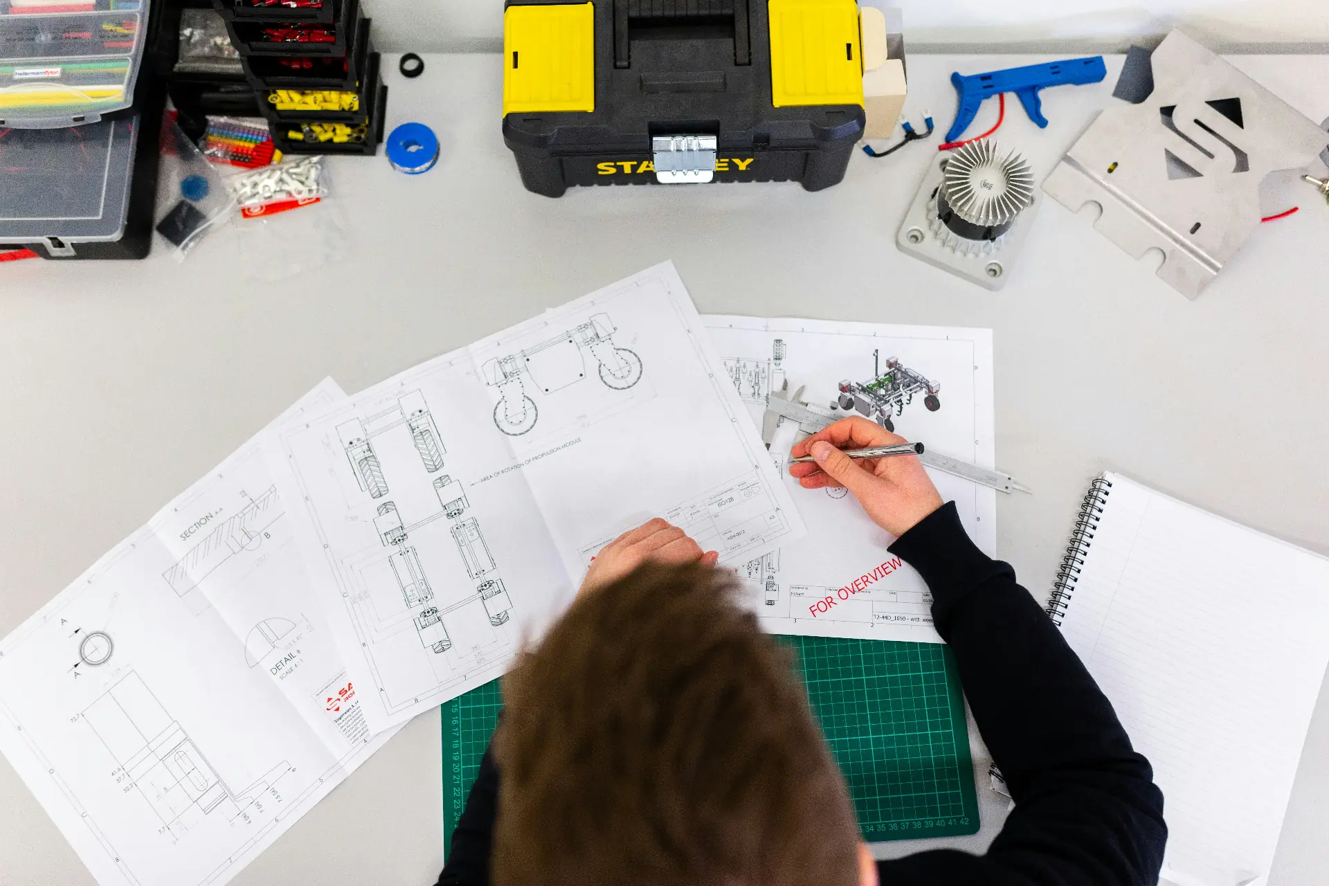 Ingénieurs SICT collaborant autour d'un prototype mécanique en atelier